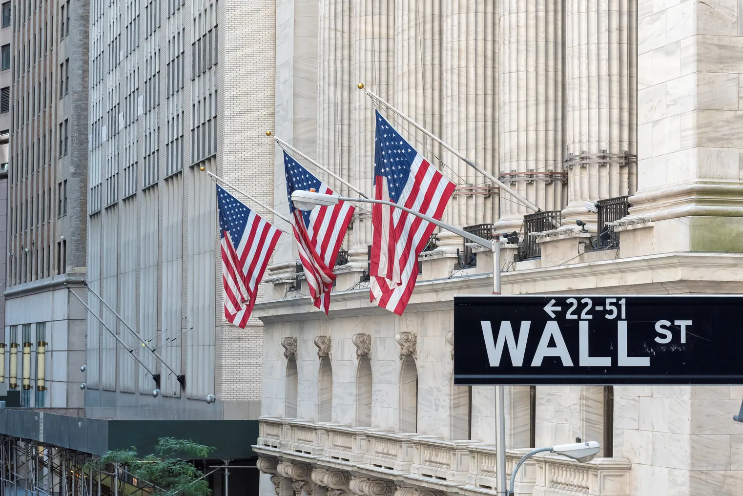 Wall Street sign with U.S. flags in background