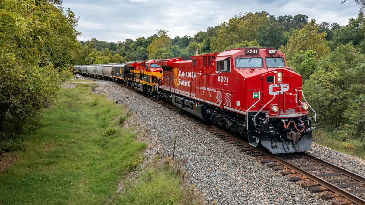 A red train displaying the Canadian Pacific logo moves along a track.