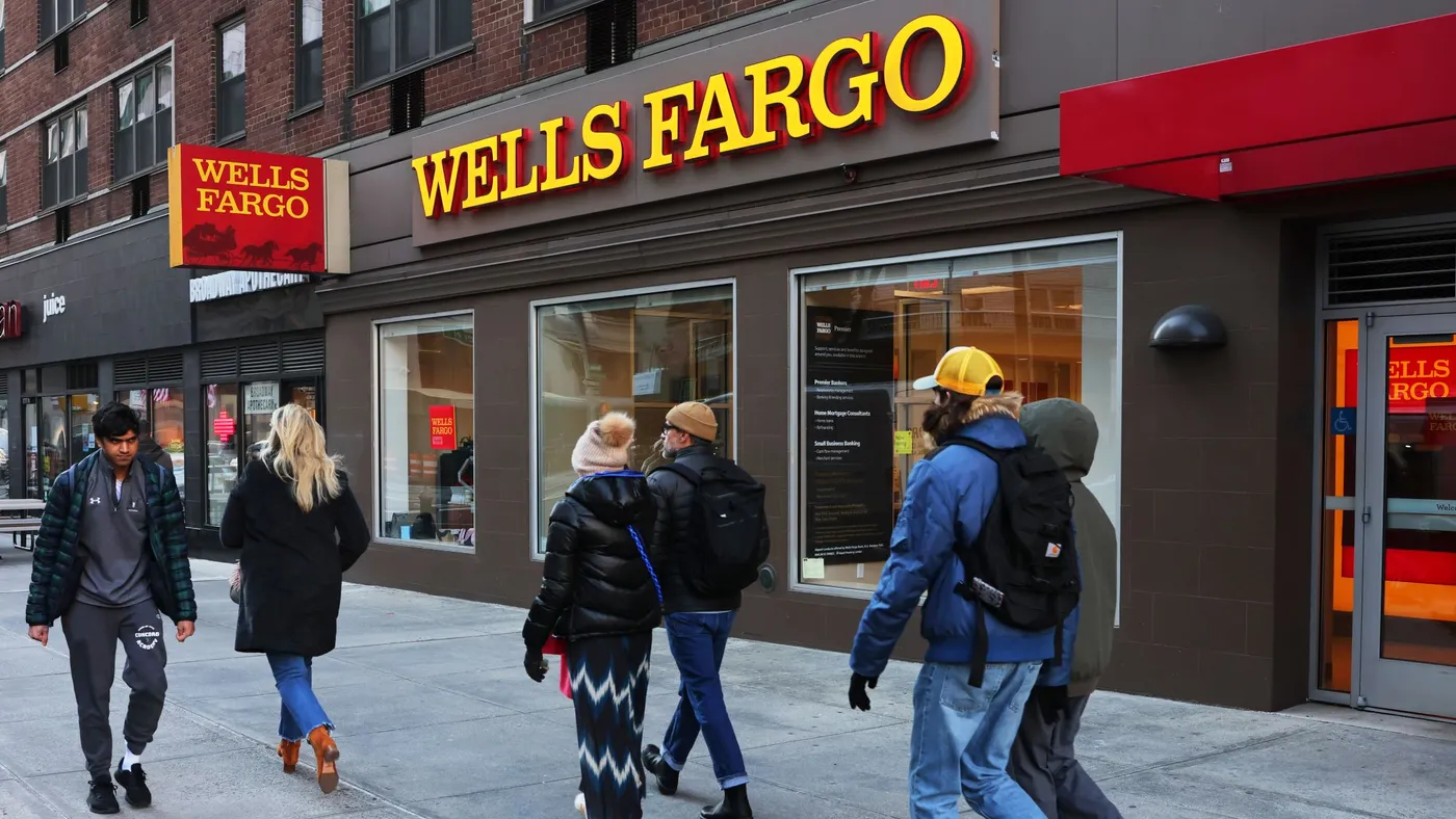 Pedestrians pass by a Wells Fargo bank branch.