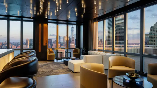 A modern apartment lounge offering views of a city skyline.
