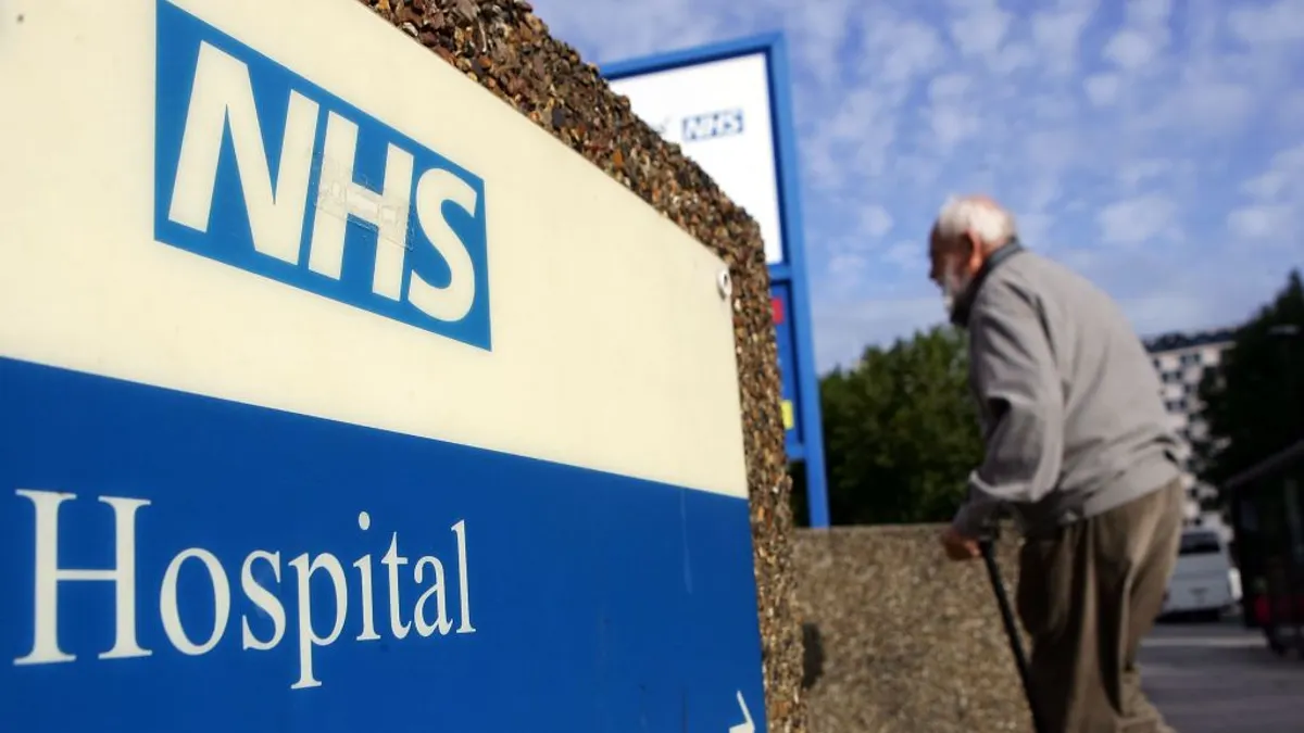 An elderly gentleman walks past a hospital sign on September 26, 2007 in London, England. In a report to be released September 27, 2007 the Healthcare Commission outlines care by the NHS Trust should provide further dignity in care to the elderly.