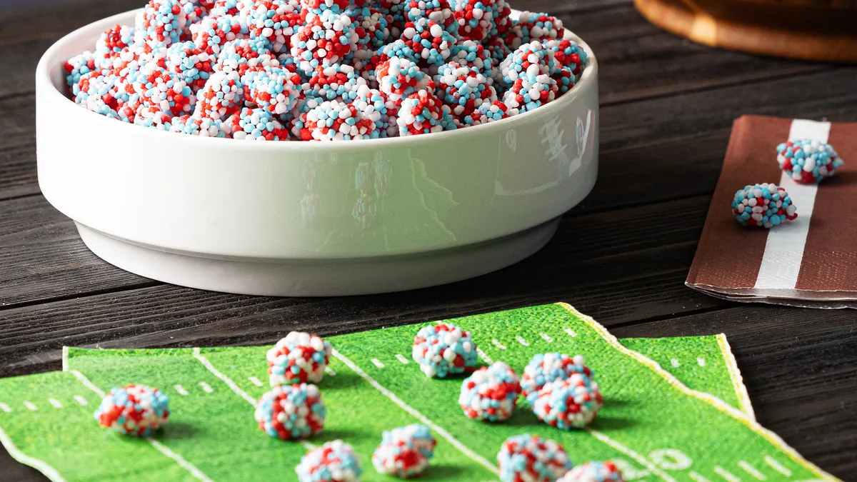 Nerds Gummy Clusters displayed in a bowl next to a stack of napkins with designs meant to replicate a football field.