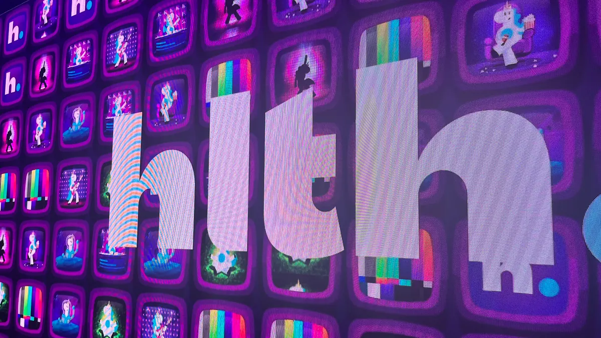 HLTH's logo is displayed in front of televisions in the entrance to the conference.