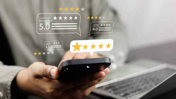 Consumer holds phone looking at online reviews, star ratings.