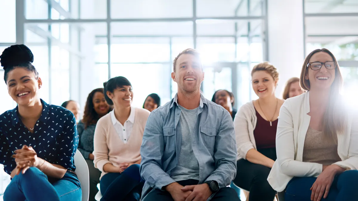 A group of employees laughs during a training session.