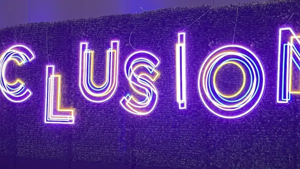 An electric sign displaying the word "inclusion" is seen at a SHRM conference
