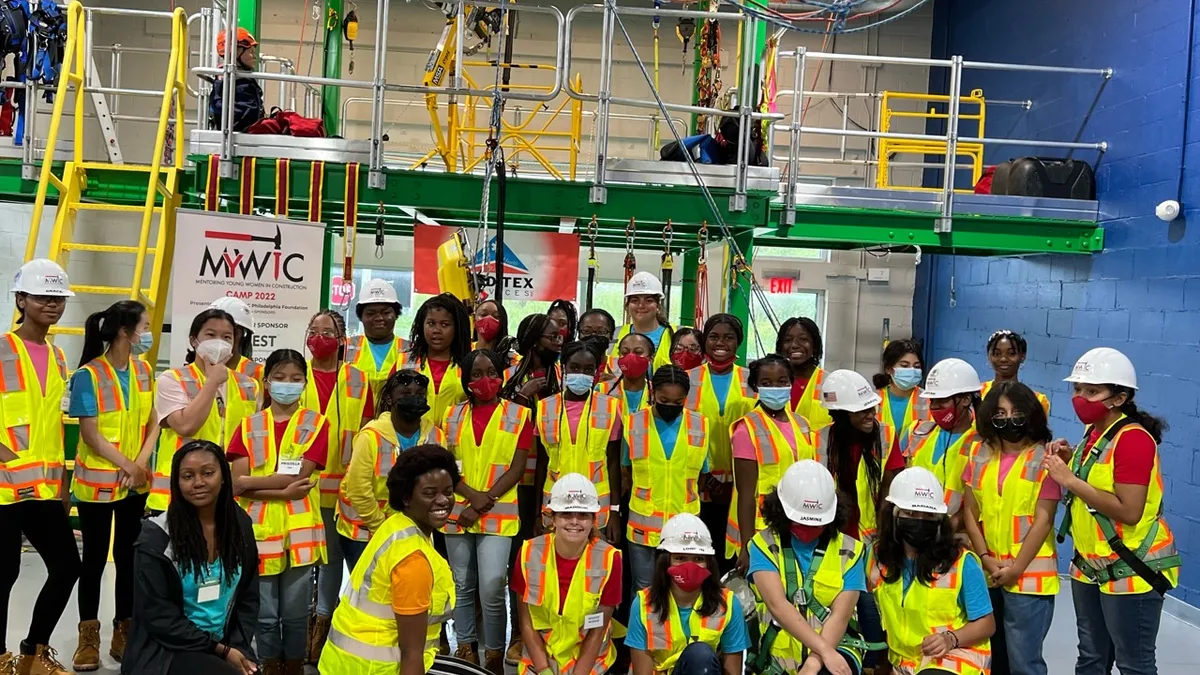 A group of teenagers in safety gear pose for a photograph.