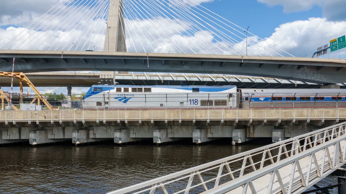 An Amtrak locomotive pulling a train on a bridge.