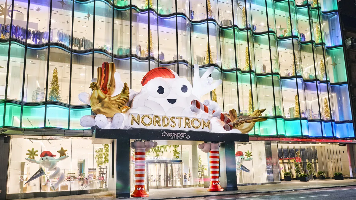 A lit-up department store with holiday decorations in front windows and entrance.