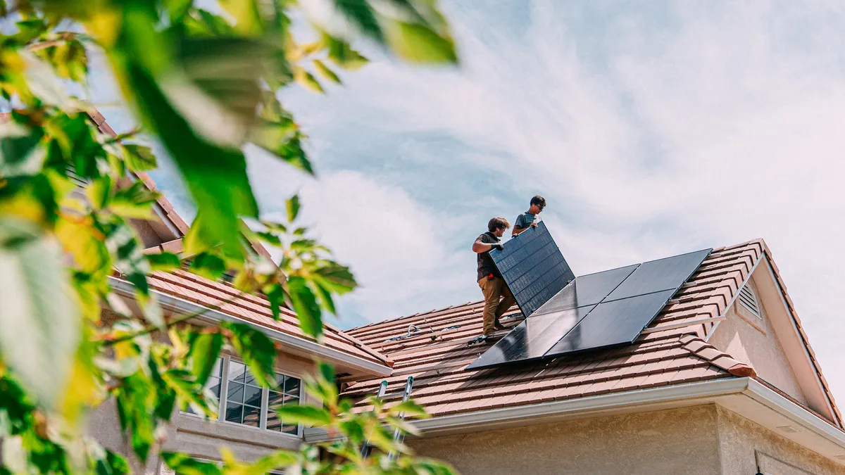 Workers installing rooftop solar panels on a Western USA home.