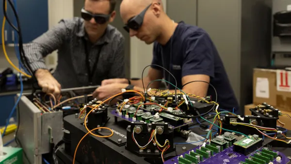 Two people working on a complex computer system