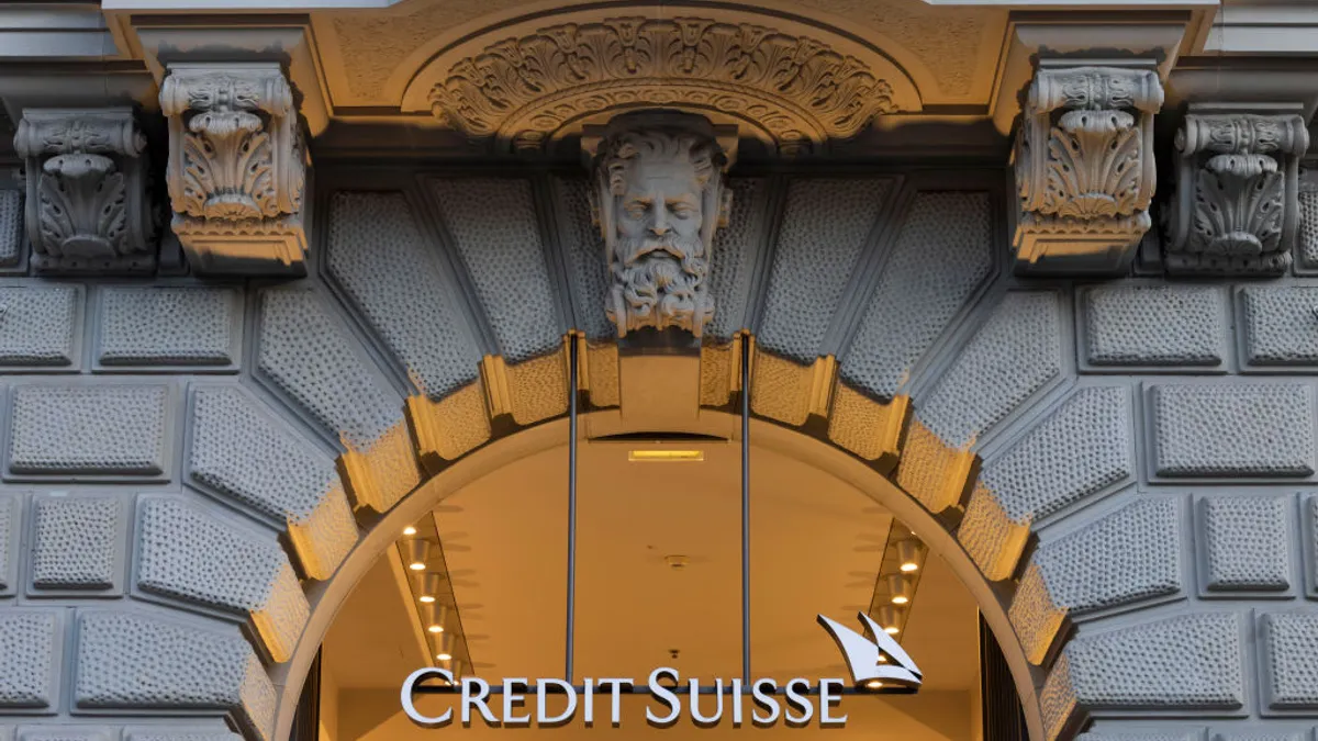 "Credit Suisse" signage hangs below a building archway.