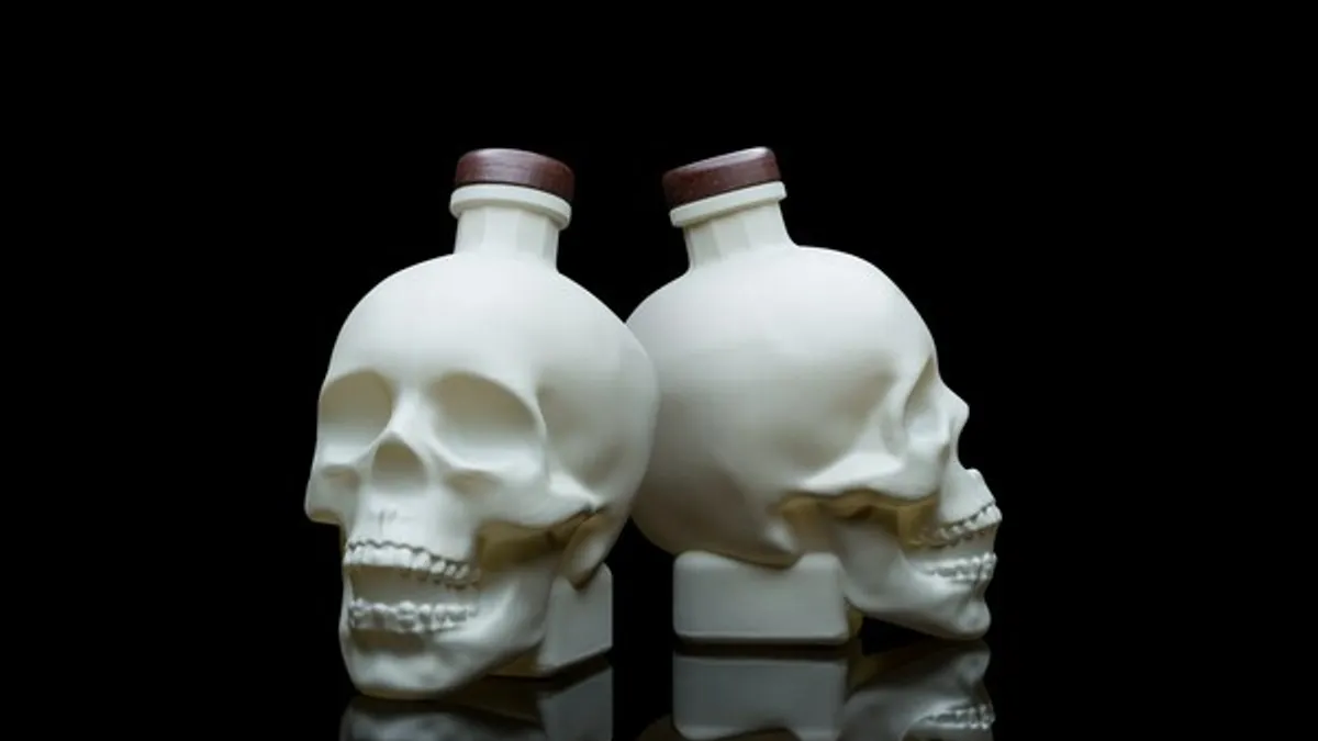 Two white, skull-shaped bottles of Crystal Head Vodka.