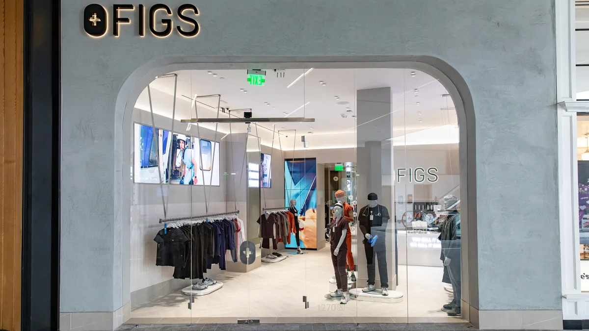 A white and black colored Figs storefront in LA with mannequins in scrubs.