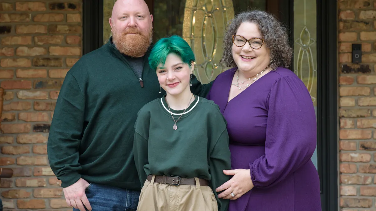 The family of an LGBTQ+ Iowa student stands in front of their home