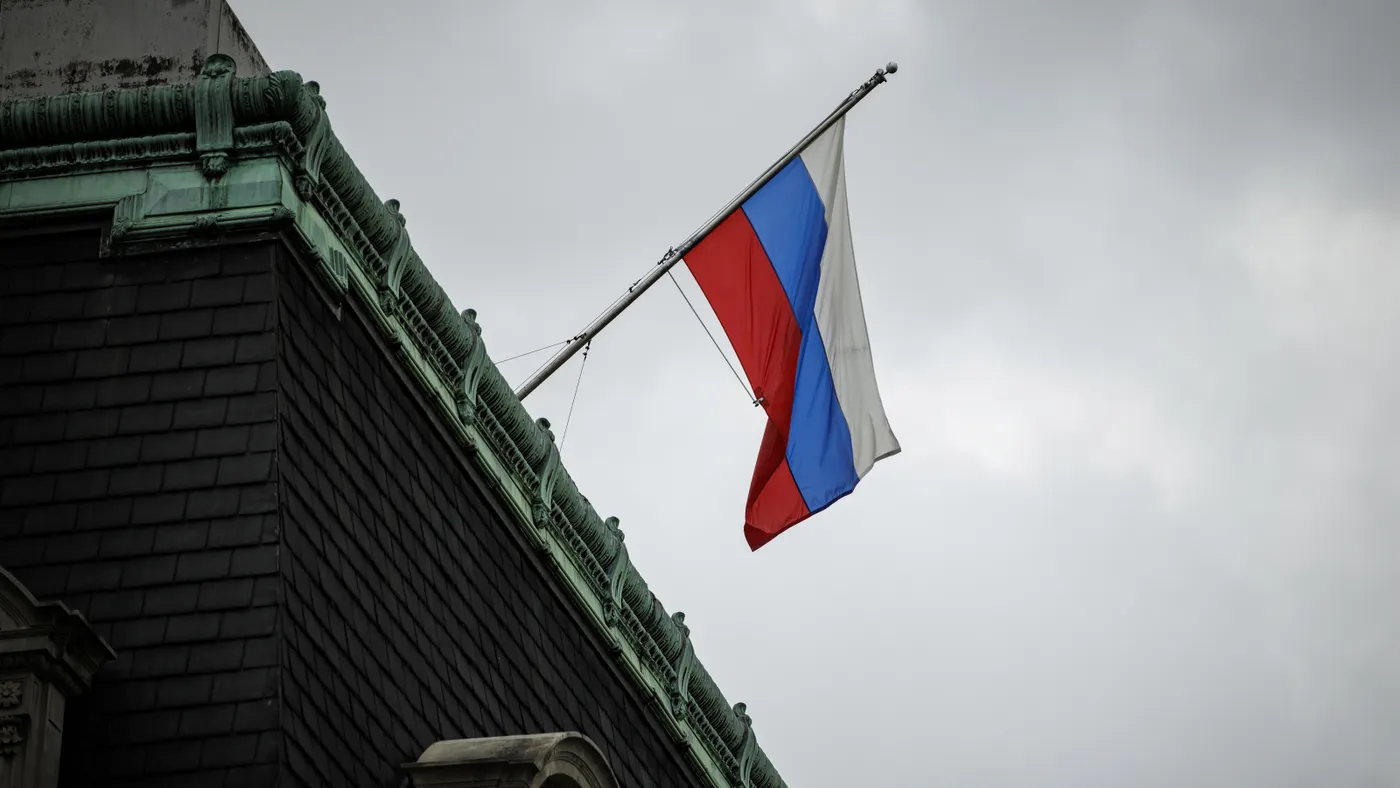 The Russian flag flies over a building on a cloudy day