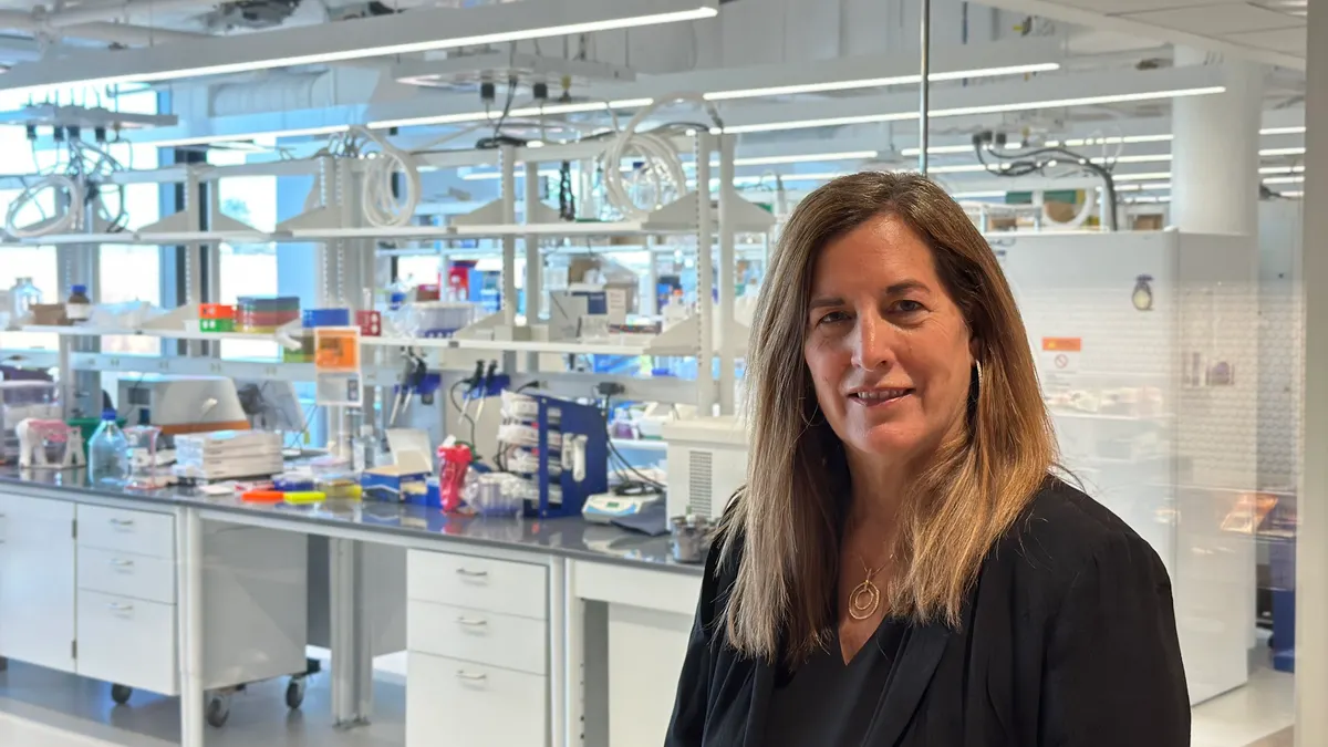 Entact Bio CEO Victoria Richon smiles at the camera with a laboratory setting in the background.