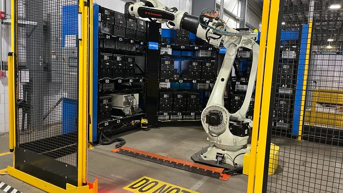 Industrial robot arm in a fenced area with “DO NOT ENTER” marking on the floor.