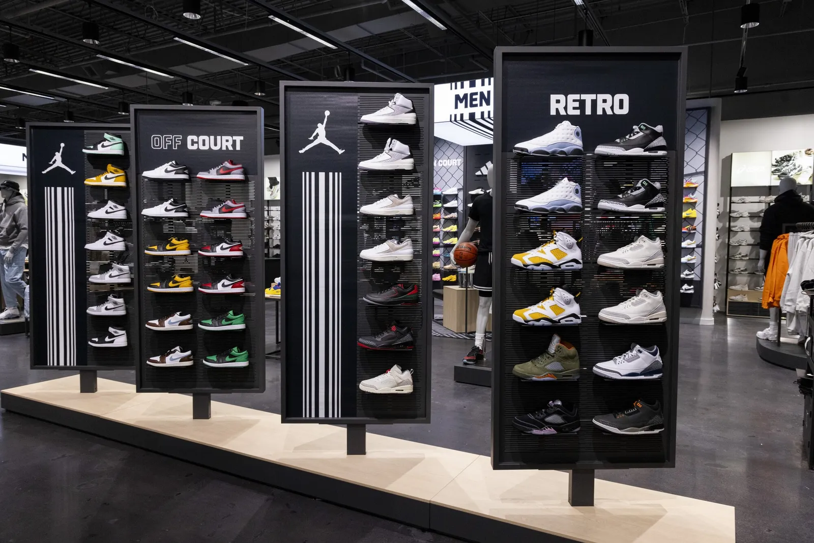 Four merchandise displays showing off different sneakers inside a Foot Locker store.