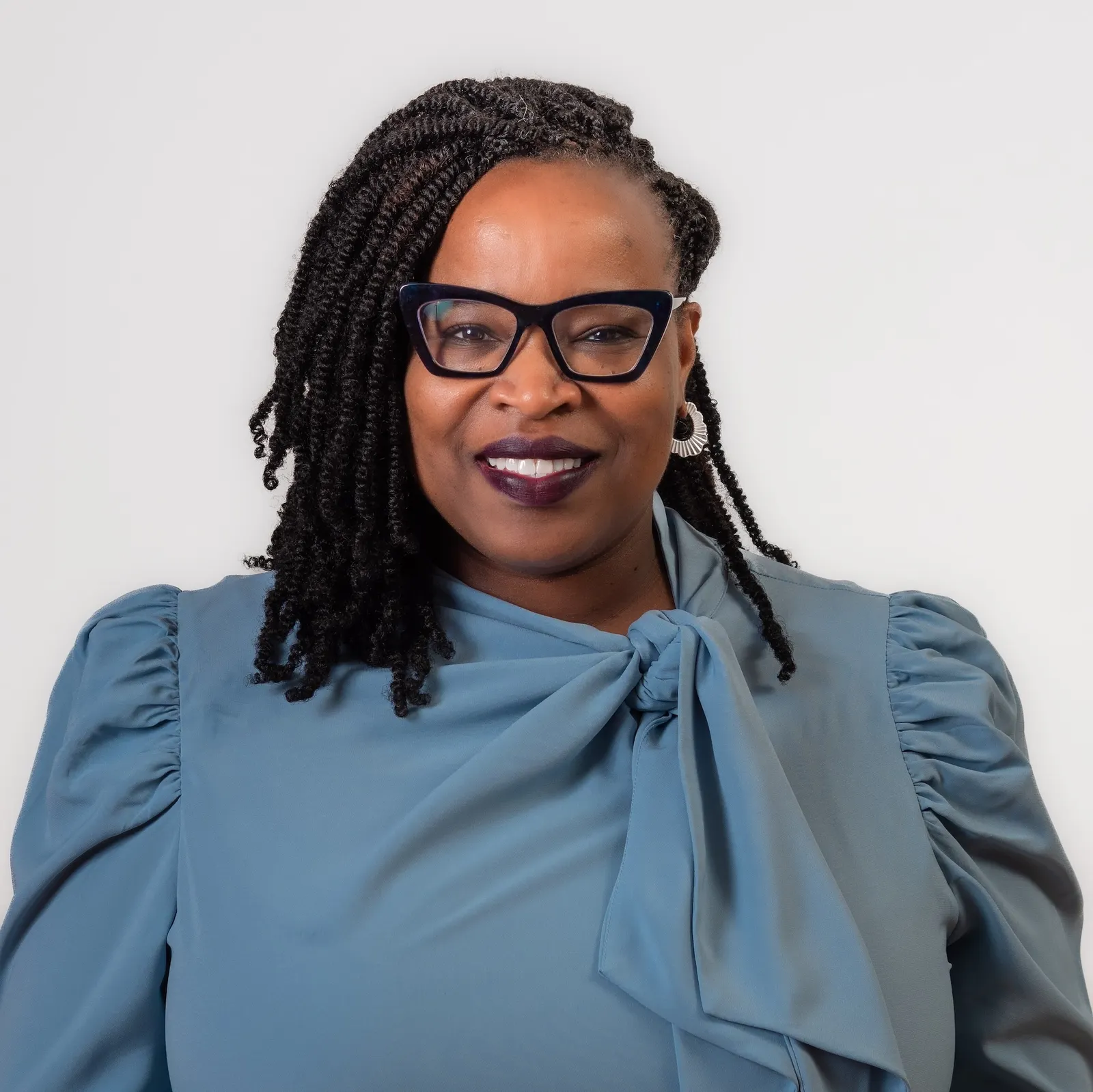 Head shot of woman in blue dress.