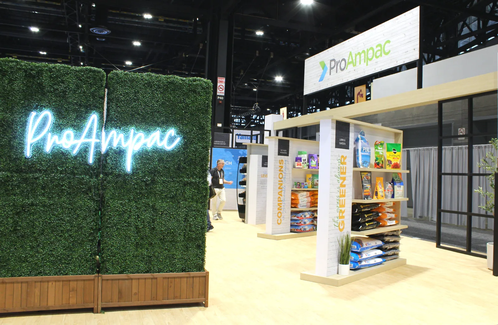 A ProAmpac conference booth with shelves displaying flexible packaging products.