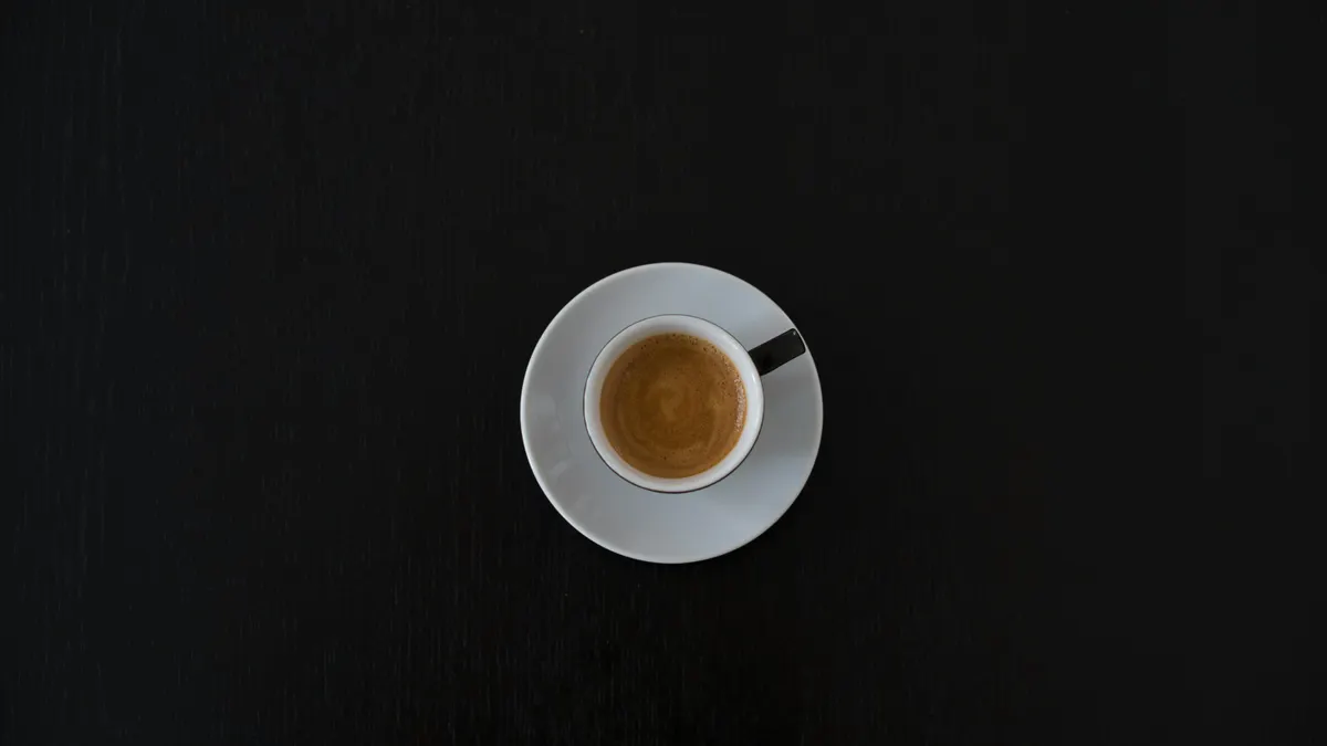 a white cup of expresso on a black background