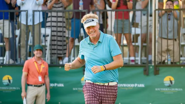 Will Ferrell, wearing colorful attire, strides up a golf course in Netflix's new show "The Hawk."
