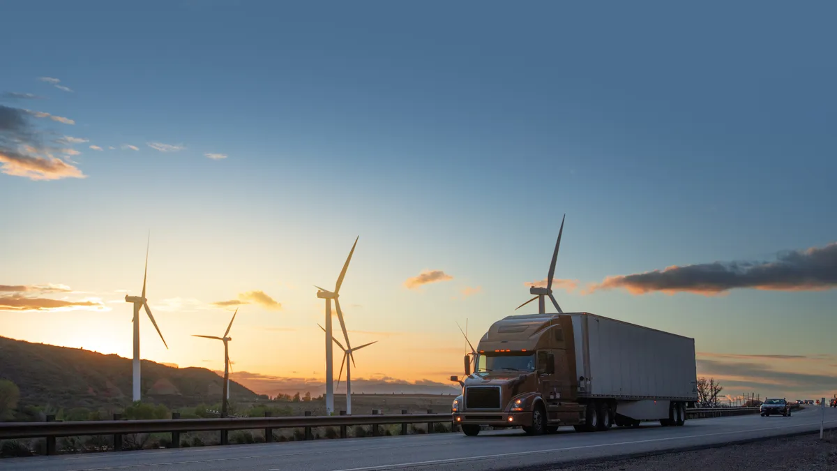 Semi truck on the road by windmills