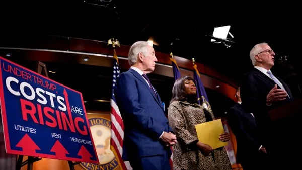 A poster that reads "Under Trump, Costs are Rising" is displayed as House Ways and Means Tax Subcommittee as lawmakers speak during a news conference.