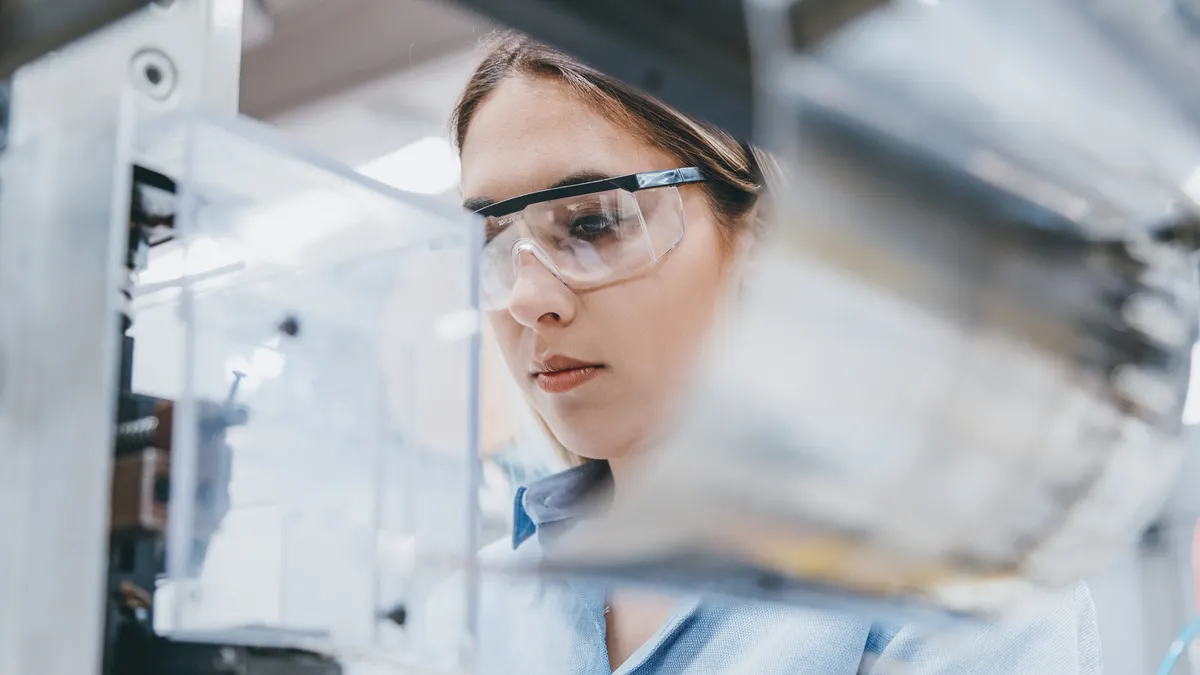 Woman in a lab wearing safety goggles