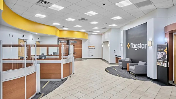 Office spaces and chairs are seen within the interior of a bank branch.