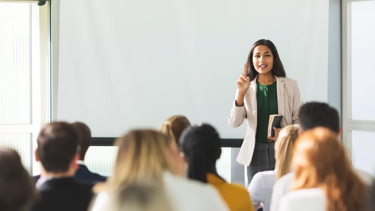 Businesswoman holding a speech in front of a group.