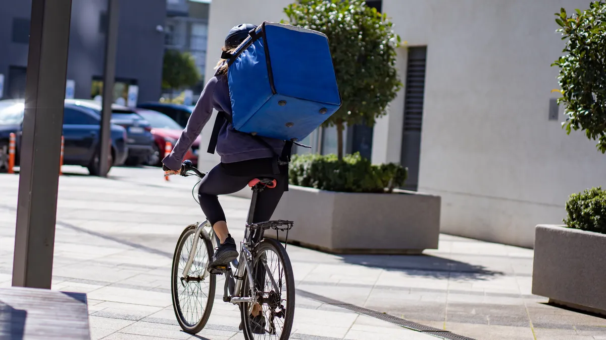 Delivery person riding electric bicycle