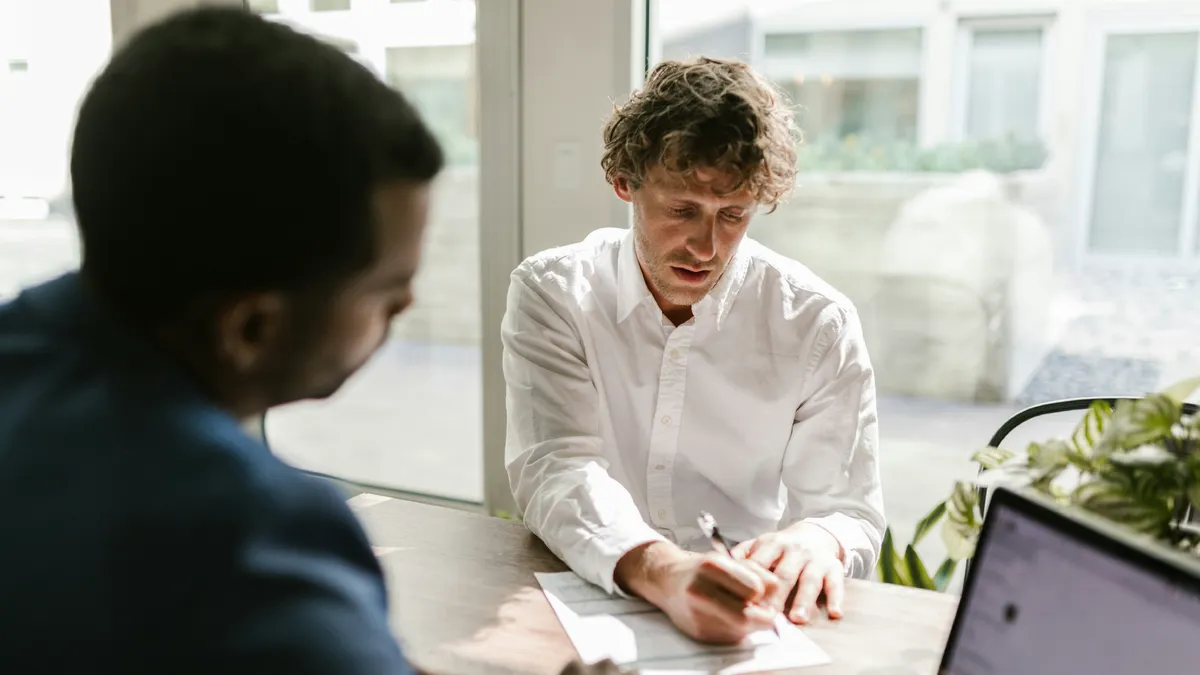 A Man Signing a Document at an Office