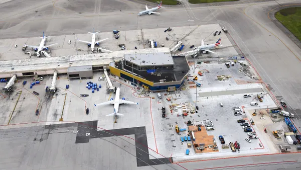 An aerial shot of an airport, with the camera overlooking the tarmac and planes.
