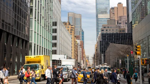 A street in New York City with pedestrians crossing.