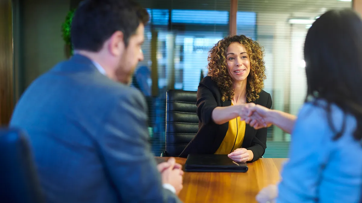 A lawyer shaking a company's executive hand to accept a new job