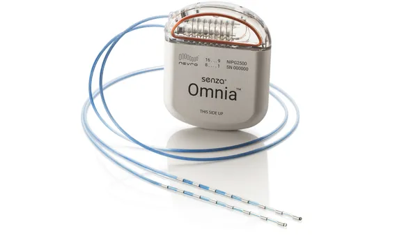 A metal, rounded device says "Senza Omnia" and has two attached leads.