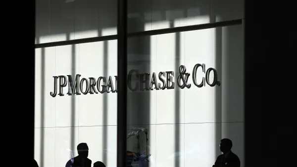 People walk in front of a JPMorgan Chase & Co. sign at its headquarters in New York City.