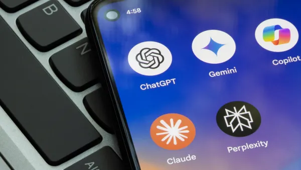 AI apps ChatGPT, Gemini, Copilot, Claude and Perplexity on a smartphone hovering over a computer keyboard .