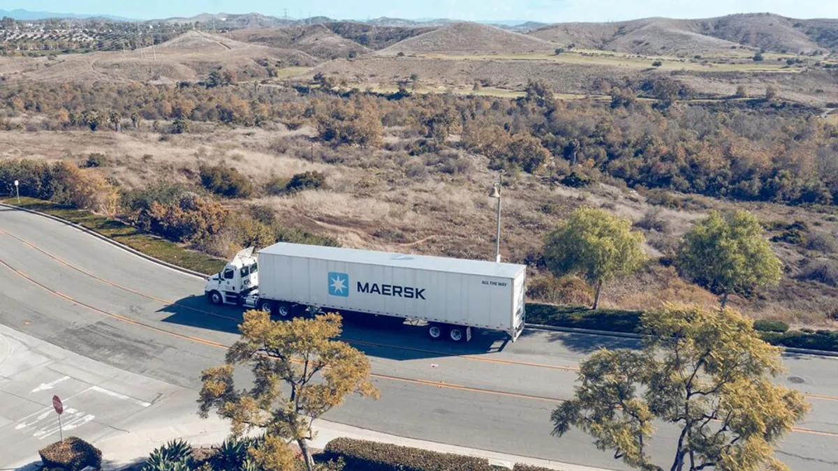 A freight truck on the road near a desert location.