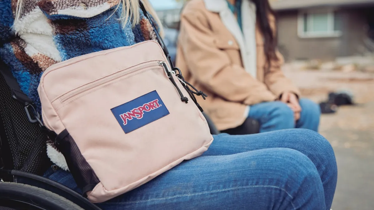 Person in a wheelchair wearing a crossbody bag from the Jansport Adaptive Collection