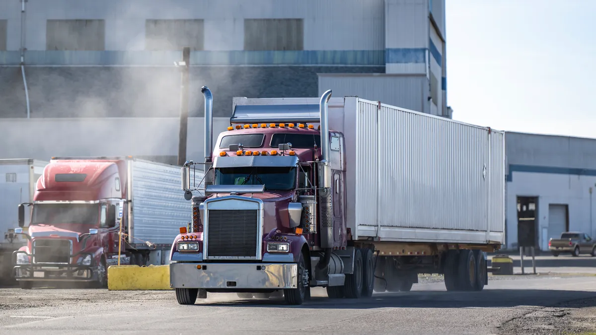 Trucks in an industrial setting by a building.