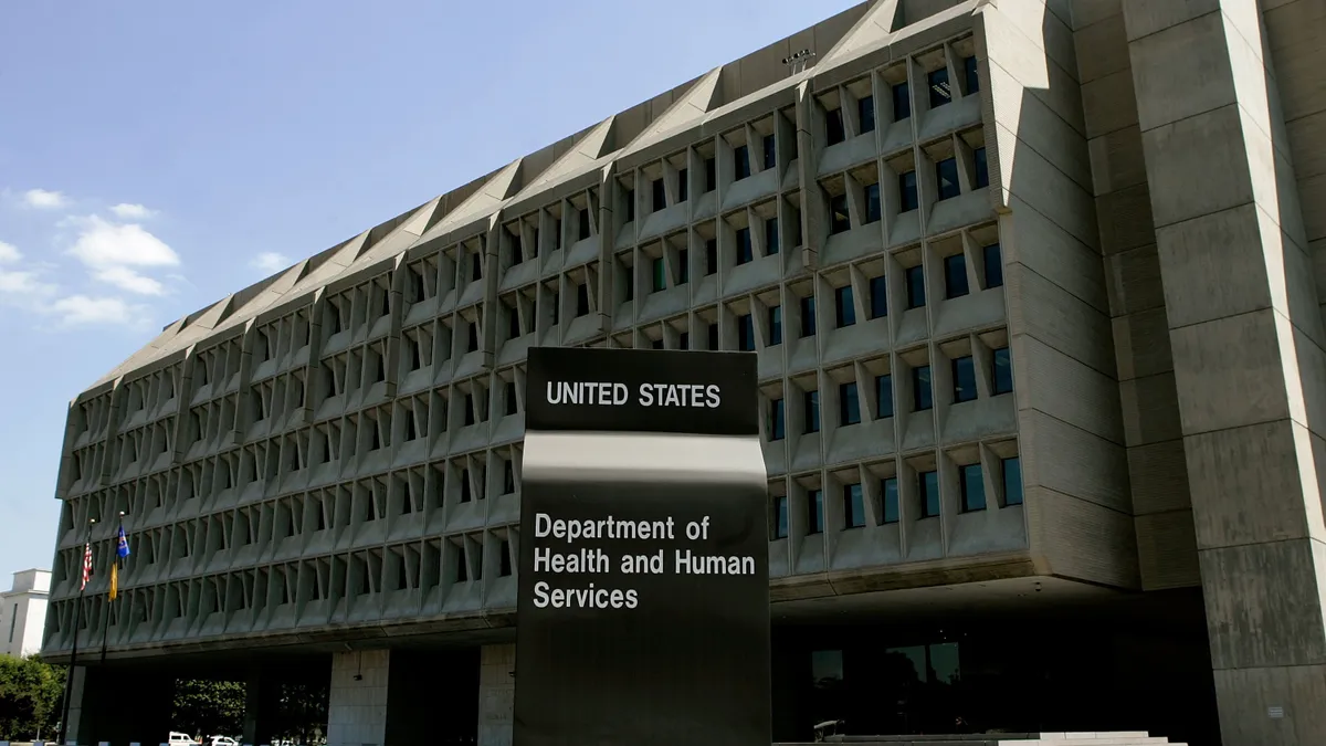 The front of the department of health and human services building with a sign in front of the exterior building