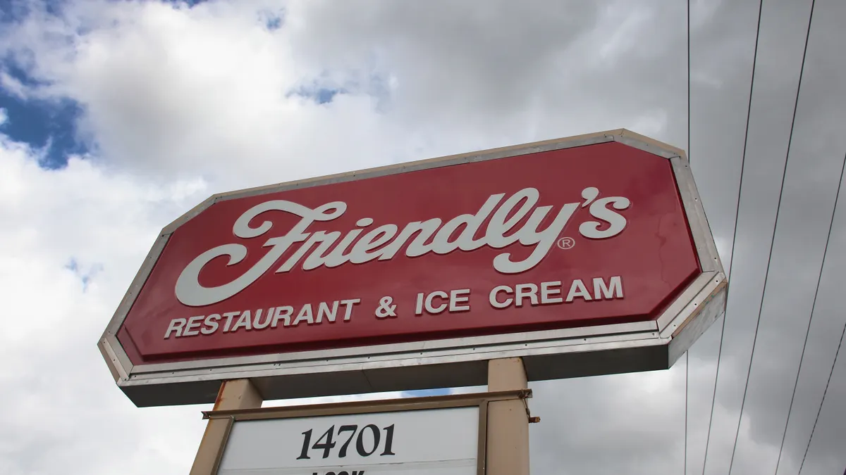 A sign for a Friendly's restaurant against gray clouds