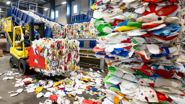 A wheel loader moves bales of plastic