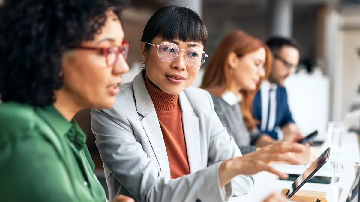 Diverse Team Collaborating Around Digital Devices in a Modern Office