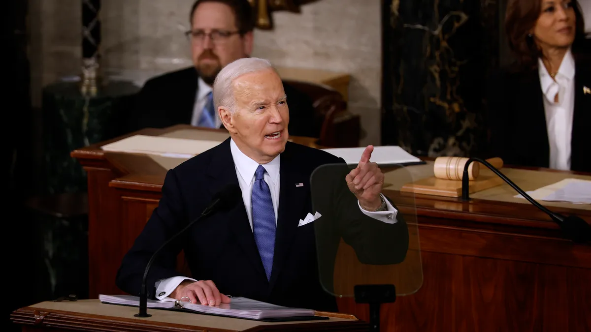 President Biden stands at podium with hand in air and finger pointed for State of the Union address to Congress on Capitol Hill.