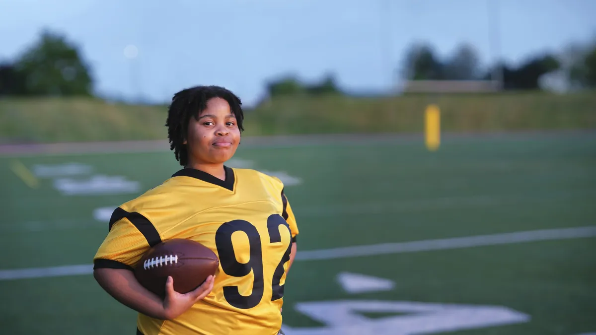 A young girl in football gear