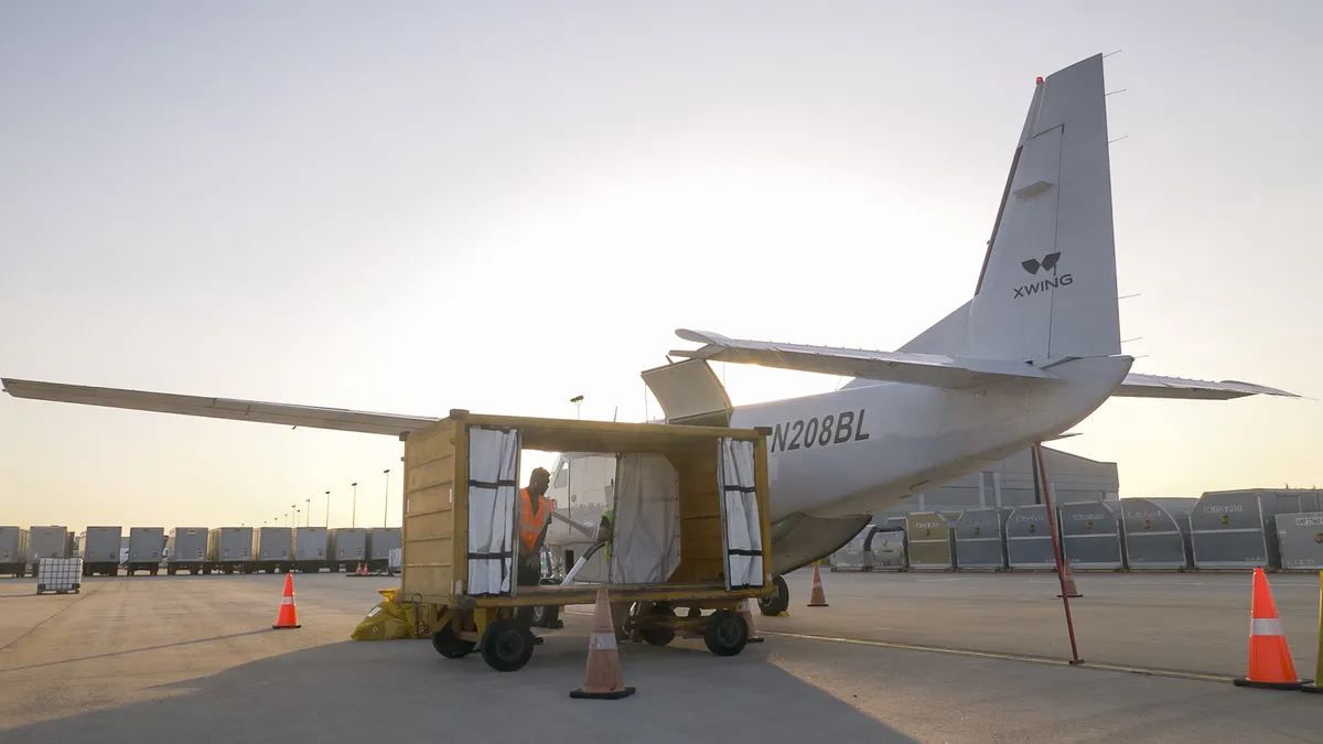 Cargo handlers work on an Xwing plane.